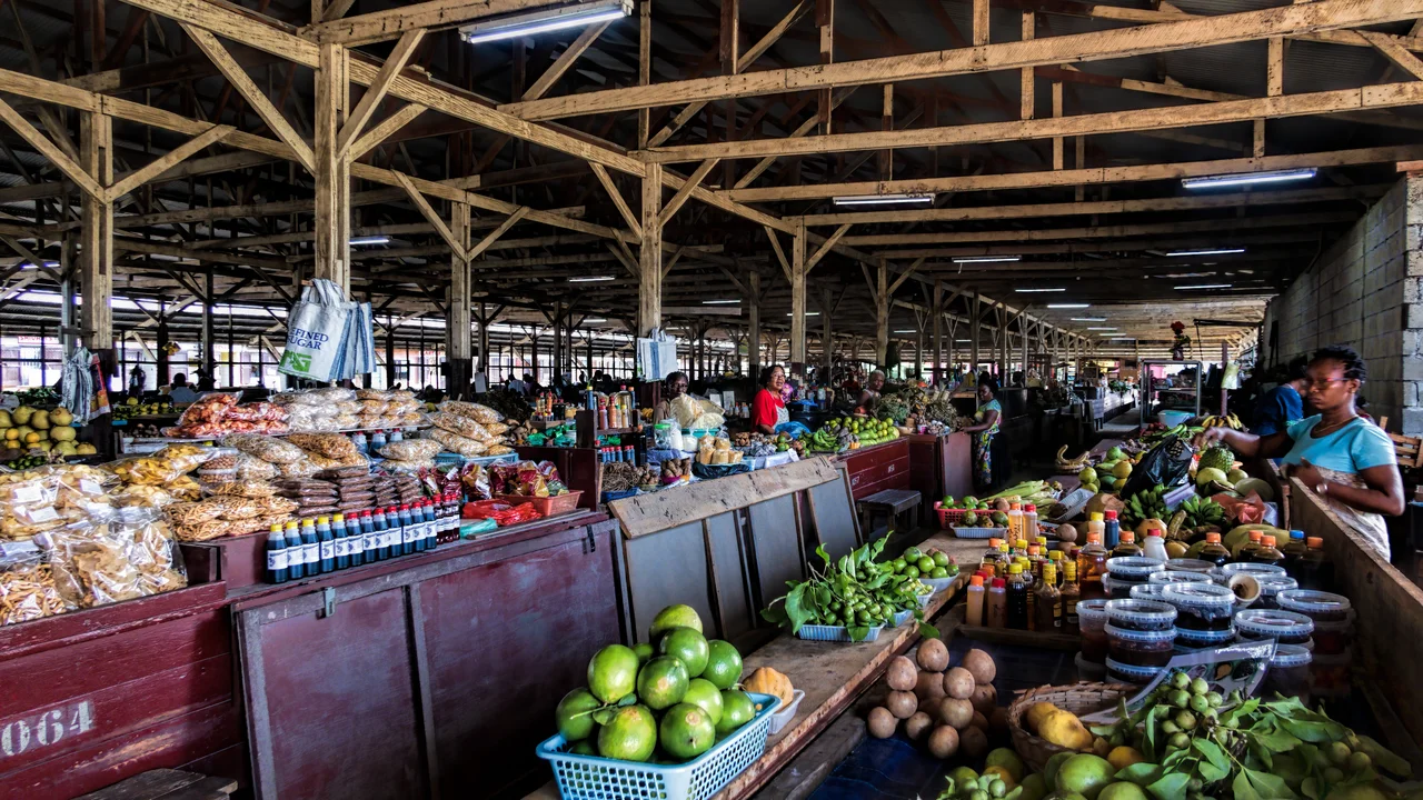 Covered retail aisles and vegetable stalls of Markt-Paramaribo-Zuid filled with fresh produce and vendor merchandise.